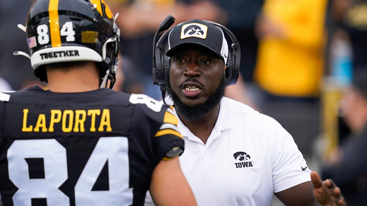 Iowa tight ends coach Abdul Hodge talks with tight end Sam LaPorta (84) before an NCAA college...