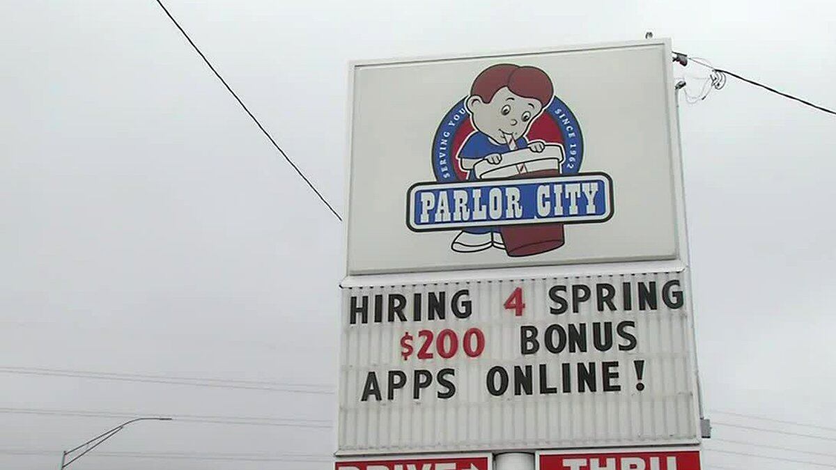 FILE - A sign at Parlor City Ice Cream in Cedar Rapids that offered $200 sign-on bonuses to get...