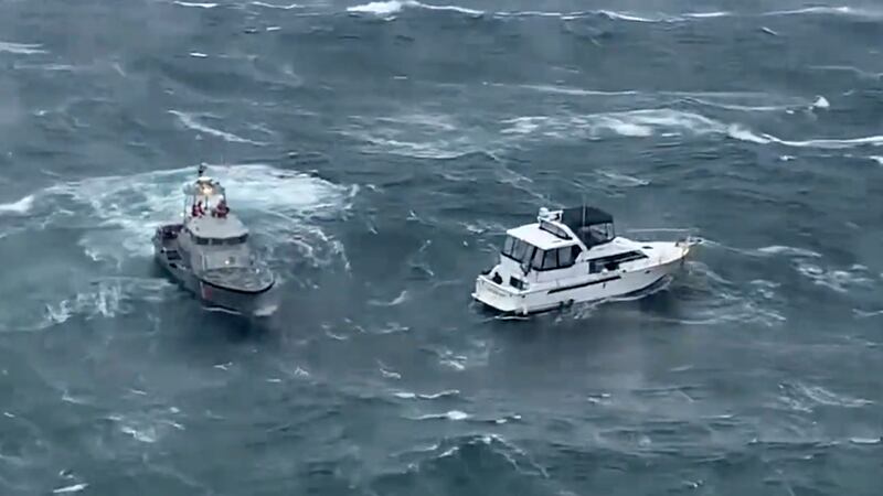 In this photo provided by the U.S. Coast Guard Pacific Northwest, a Coast Guard ship, left,...