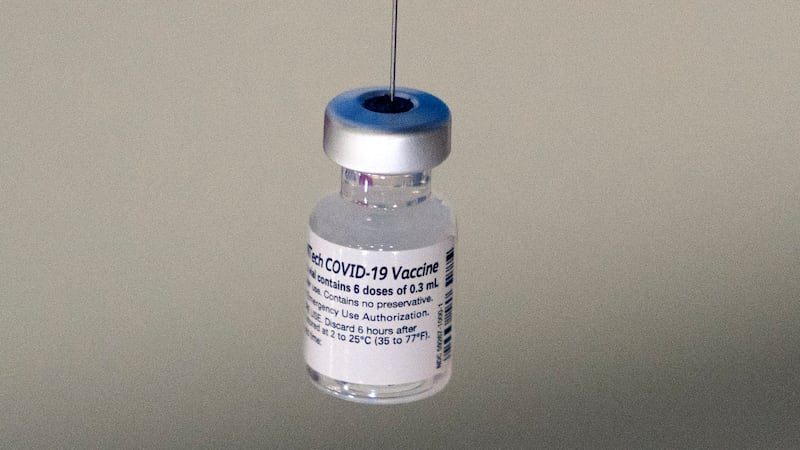 FILE - A syringe is placed into a vial of Pfizer-BioNTech vaccination at a COVID-19 clinic in...
