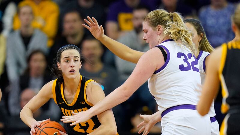 Iowa guard Caitlin Clark (22) passes around Northern Iowa center Rachael Heittola (32) during...