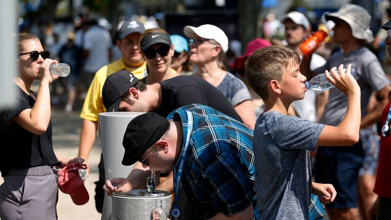 FILE - Tennis fans drink water on a hot day at the USTA Billie Jean King National Tennis...