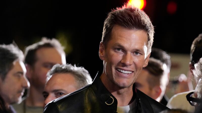 NFL quarterback Tom Brady, a cast member and producer of "80 for Brady," looks down the carpet...