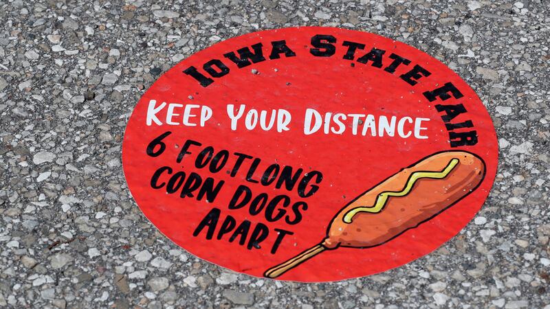 A sign directs visitors to social distance at the Taste of the Fair to be held this weekend,...